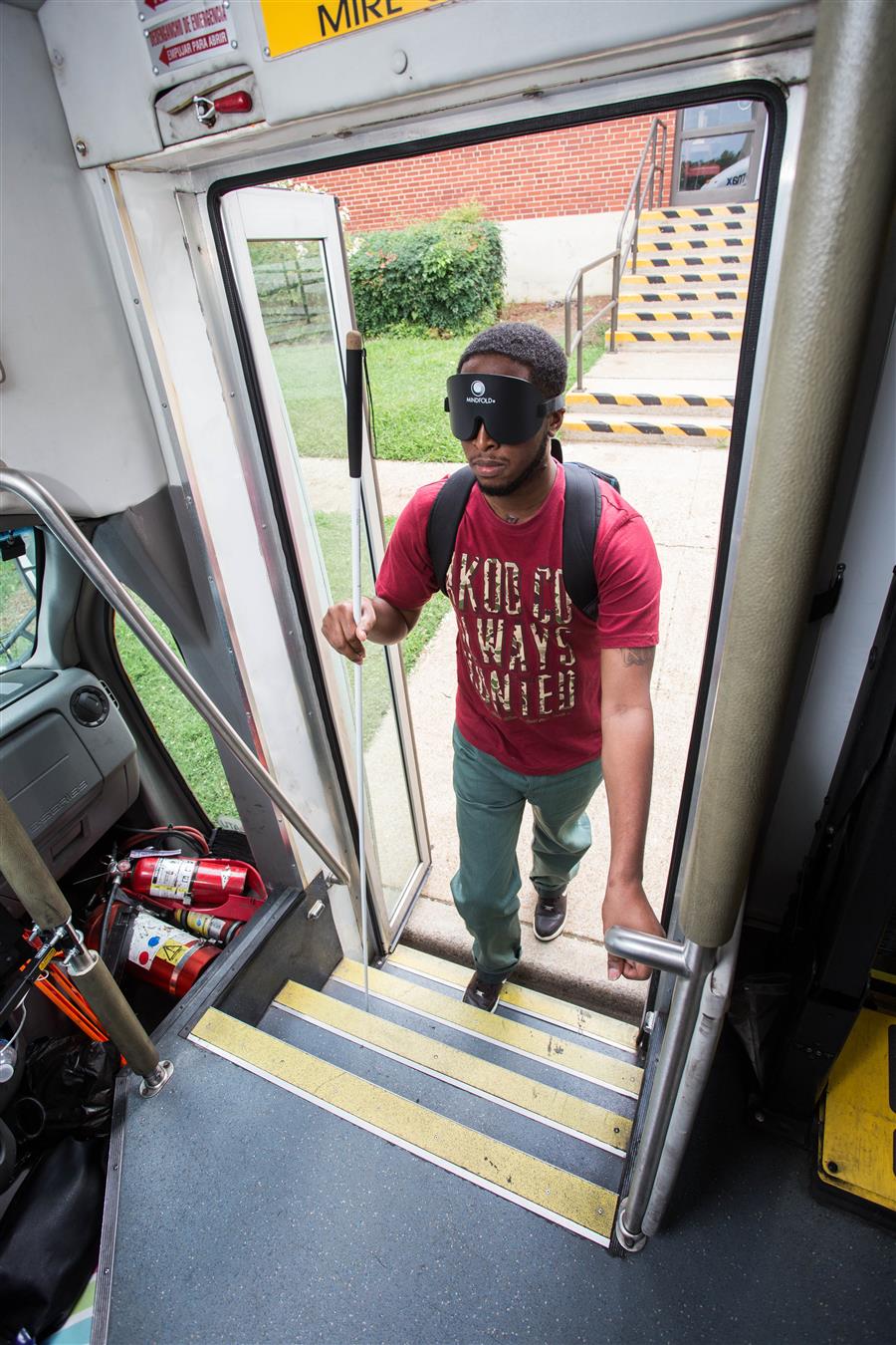 A student walking onto a bus.